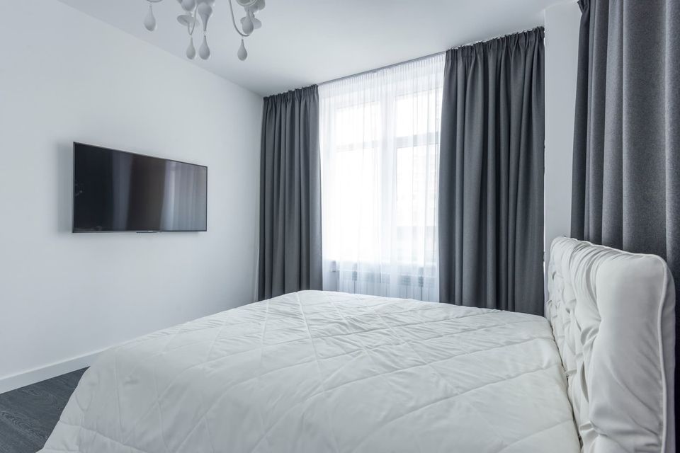 Phòng ngủ hiện đại với cửa sổ lớn và rèm sáng màu.