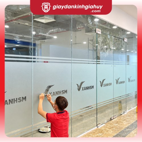 Thi công decal mờ có dải ngang và logo trên vách kính văn phòng.